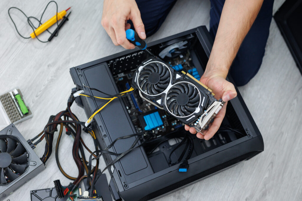 Technician installing a graphics card into a desktop computer during a PC build